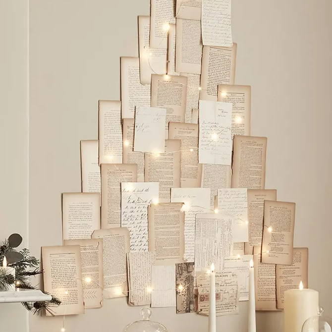 Letters and book pages arranged in a tree shape with fairy lights.
