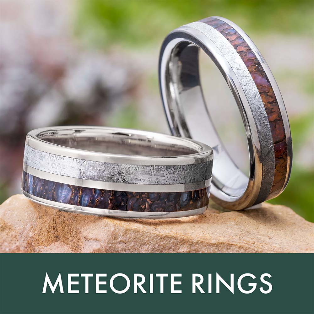 Two meteorite rings displayed on a stone surface.
