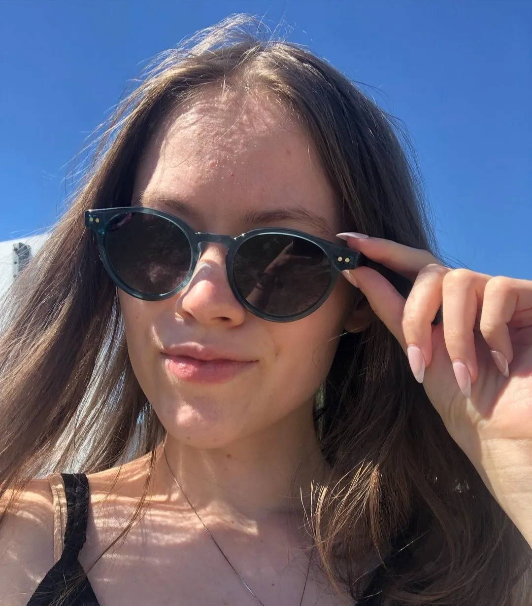 Femme portant des lunettes de soleil Flash rondes bleues avec verres polarisés gris