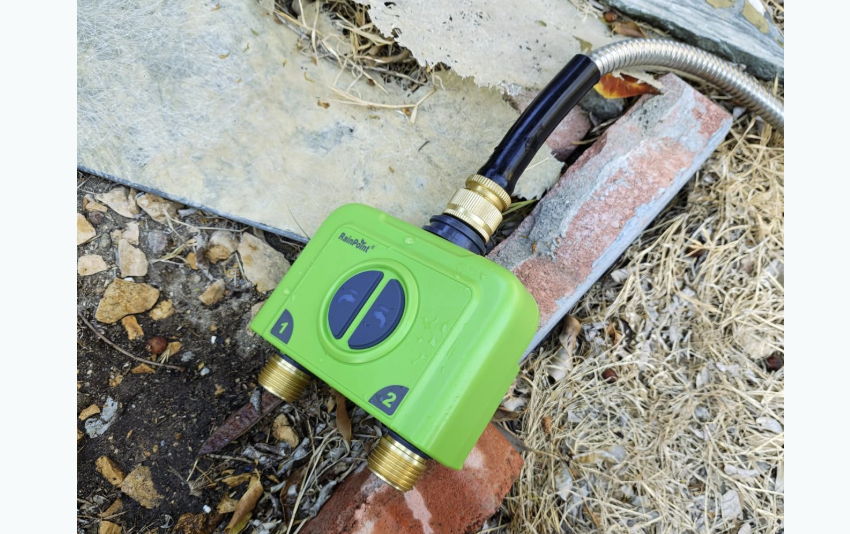 Green valve connected to pipes on the ground.