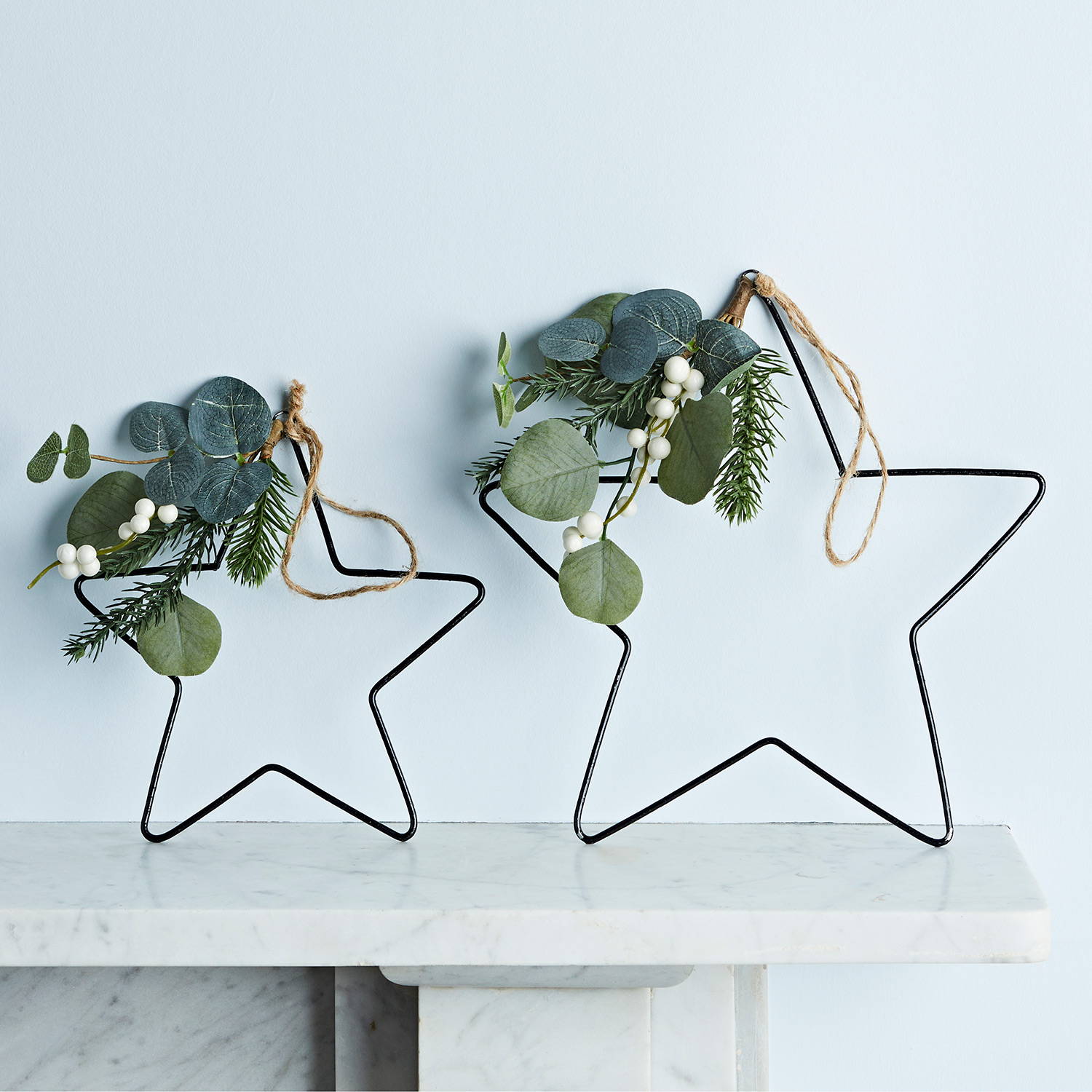 Eucalyptus and white berry star decorations sat on mantel