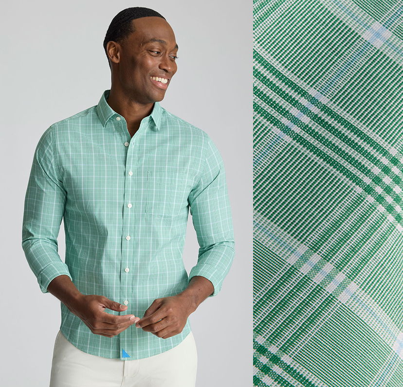 Smiling man in a green plaid shirt against a light background.