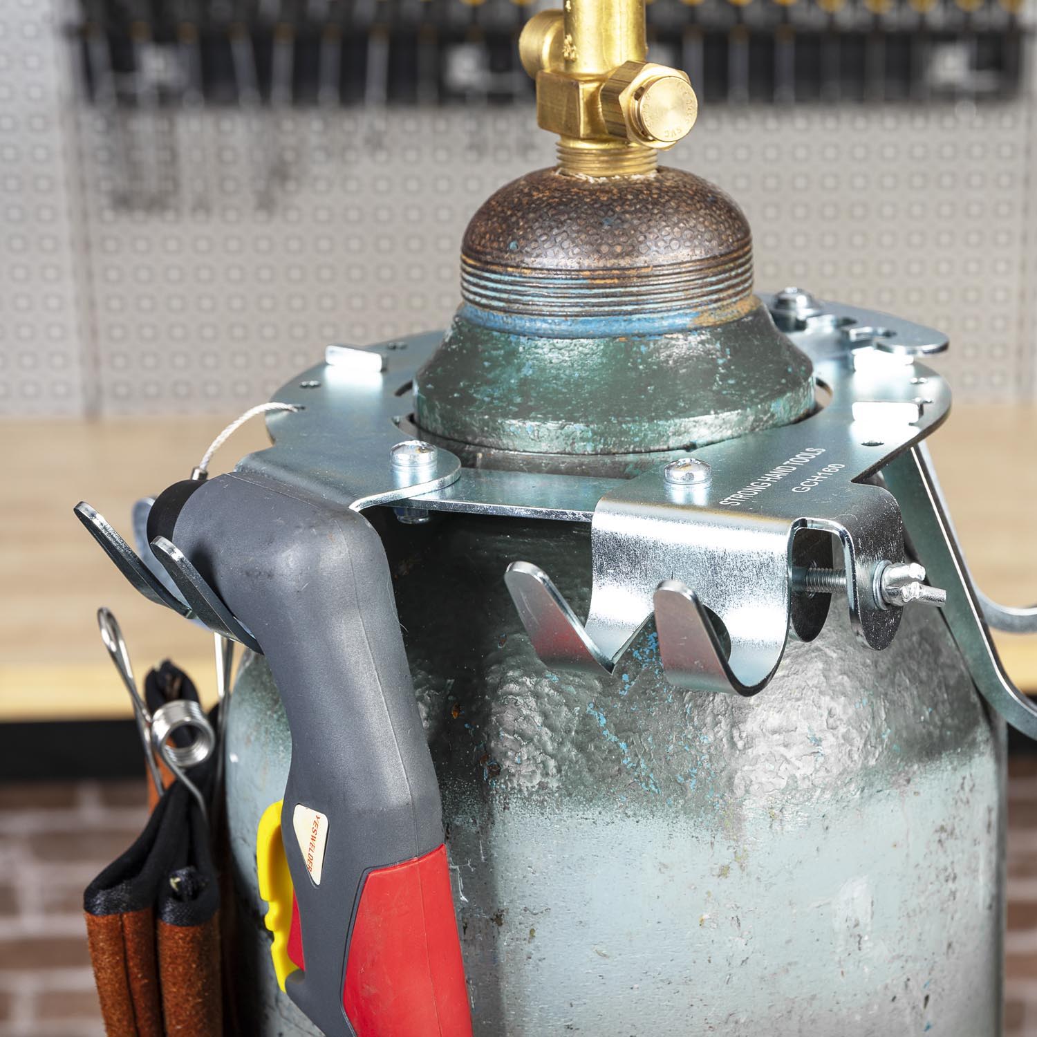 A close-up of a gas cylinder with tools attached.