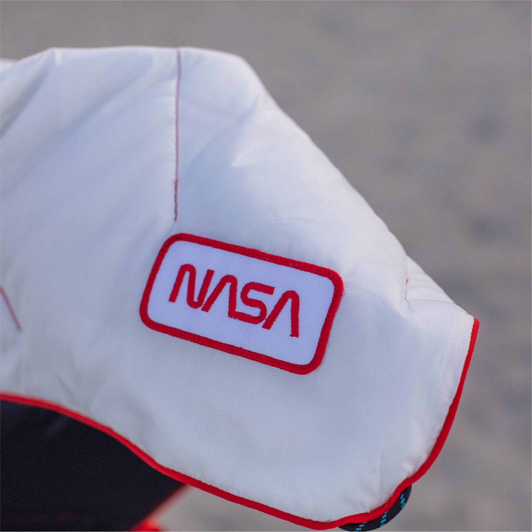 White NASA worm logo patch on a Rumpl blanket