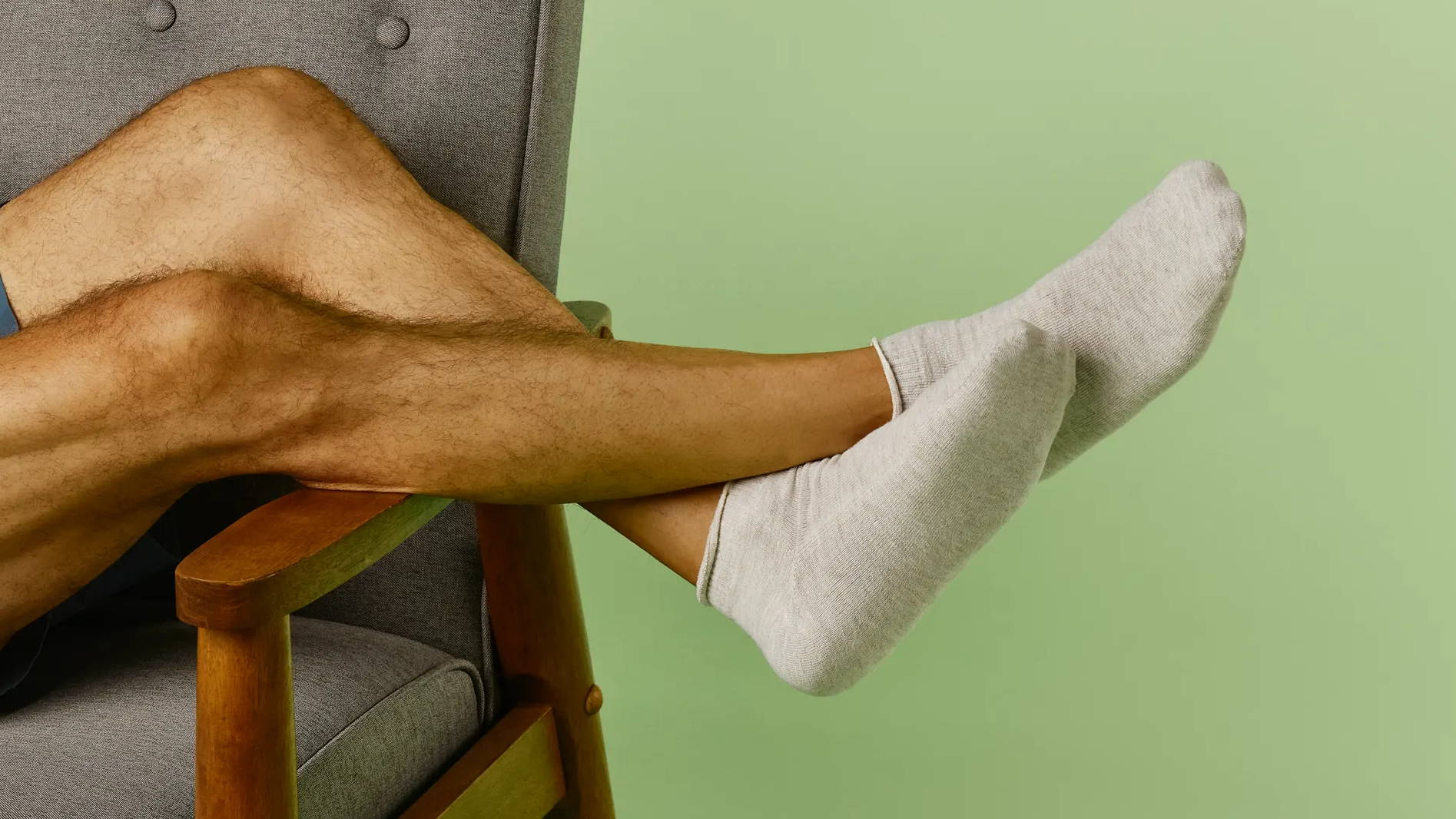 Man on chair wearing SmartKnit Mini Crew Seamless Socks