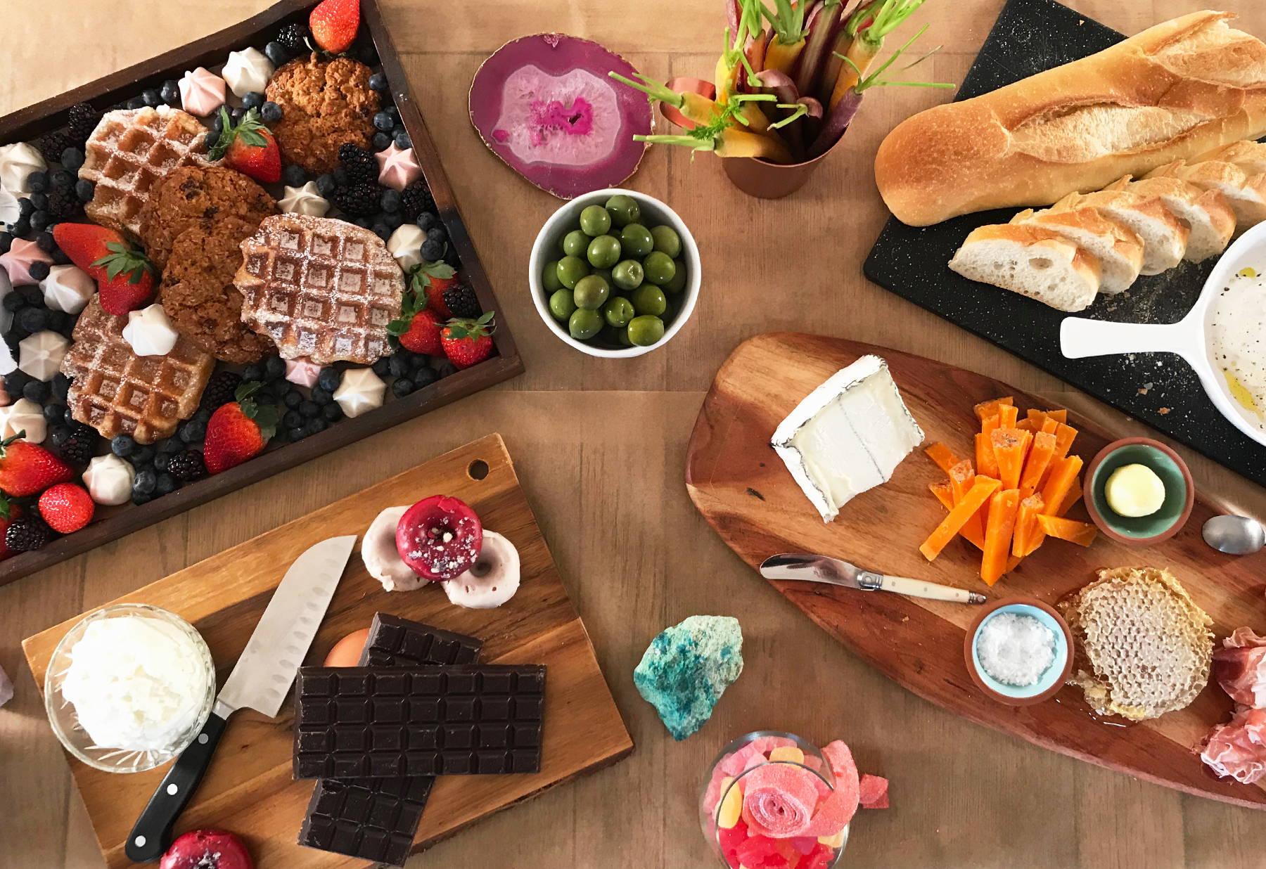 Unicorn Snot's Galentine's Day snack spread has cheeses, meats, waffles, olives, cookies, donuts, and chocolate.