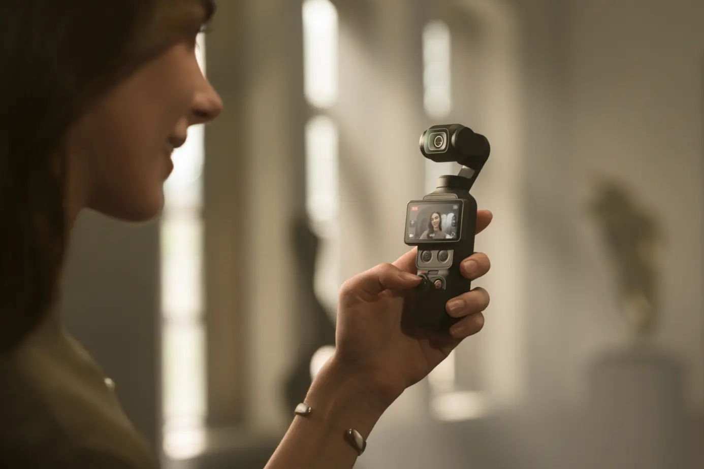 Person holding an Osmo Pocket 4 in an art gallery.