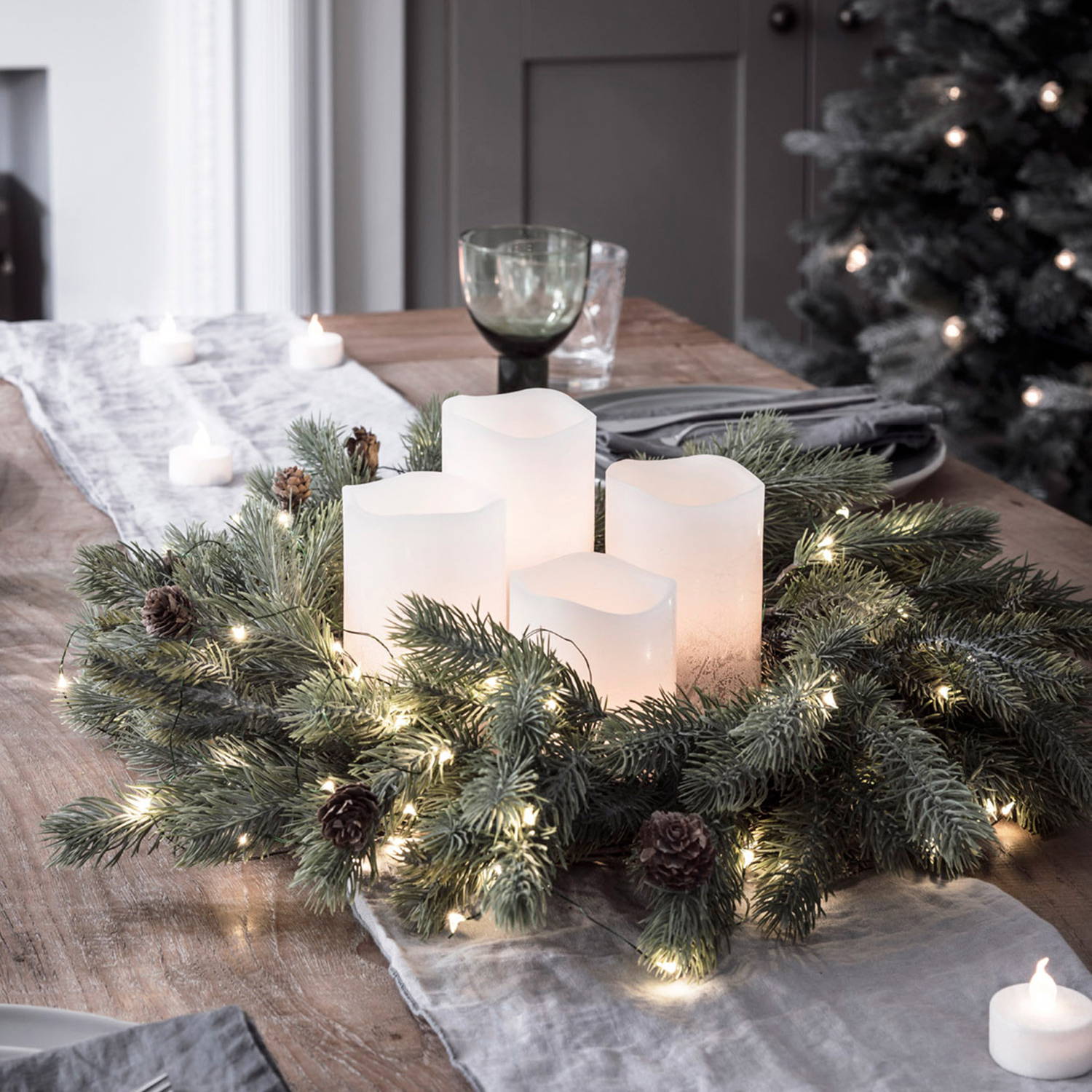 50cm Frosted Berry & Pinecone Wreath Micro Light Bundle on a table top with candles in the centre