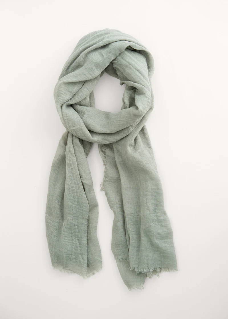 A light green sage scarf with raw hem detailing