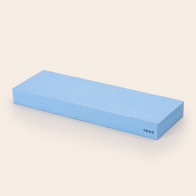 A blue Misen 1000-grit Sharpening Stone, seen from an angle with the number 1000 visible along the edge.