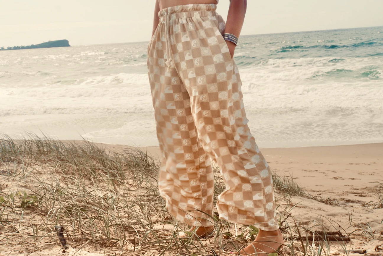 standing barefoot on the beach in checkerboard beach loungers