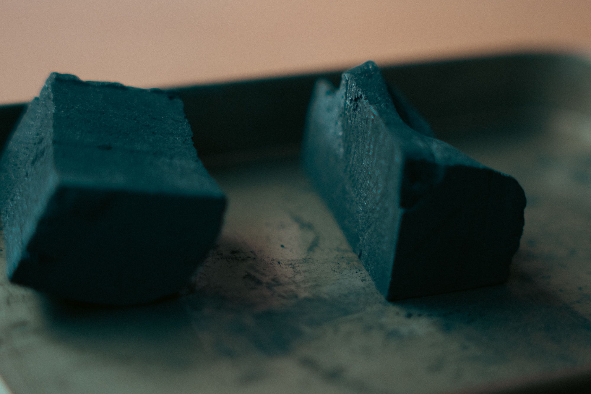 Two pieces of blue chalk on a metal tray.