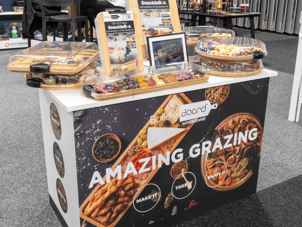 Display table with food samples and promotional materials for Amazing Grazing.