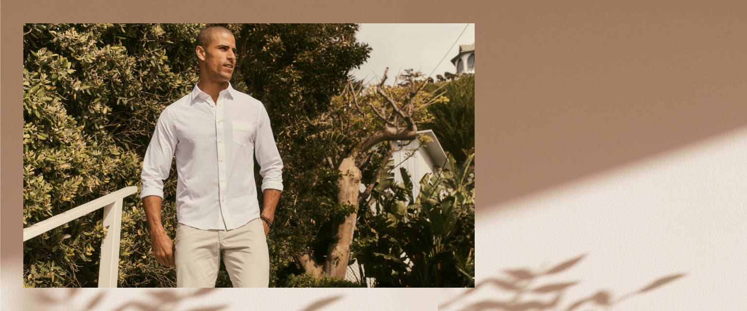 Model is wearing UNTUCKit white performance button down. 