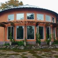 A rounded building with natural plaster exterior walls