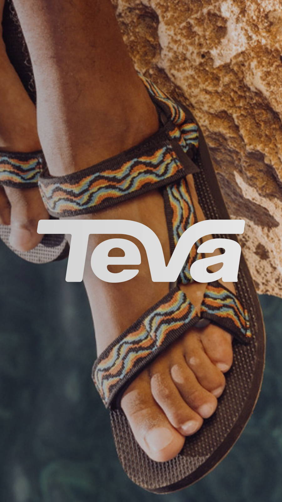 Man's feet hanging off the edge of a boulder wearing Teva sandals