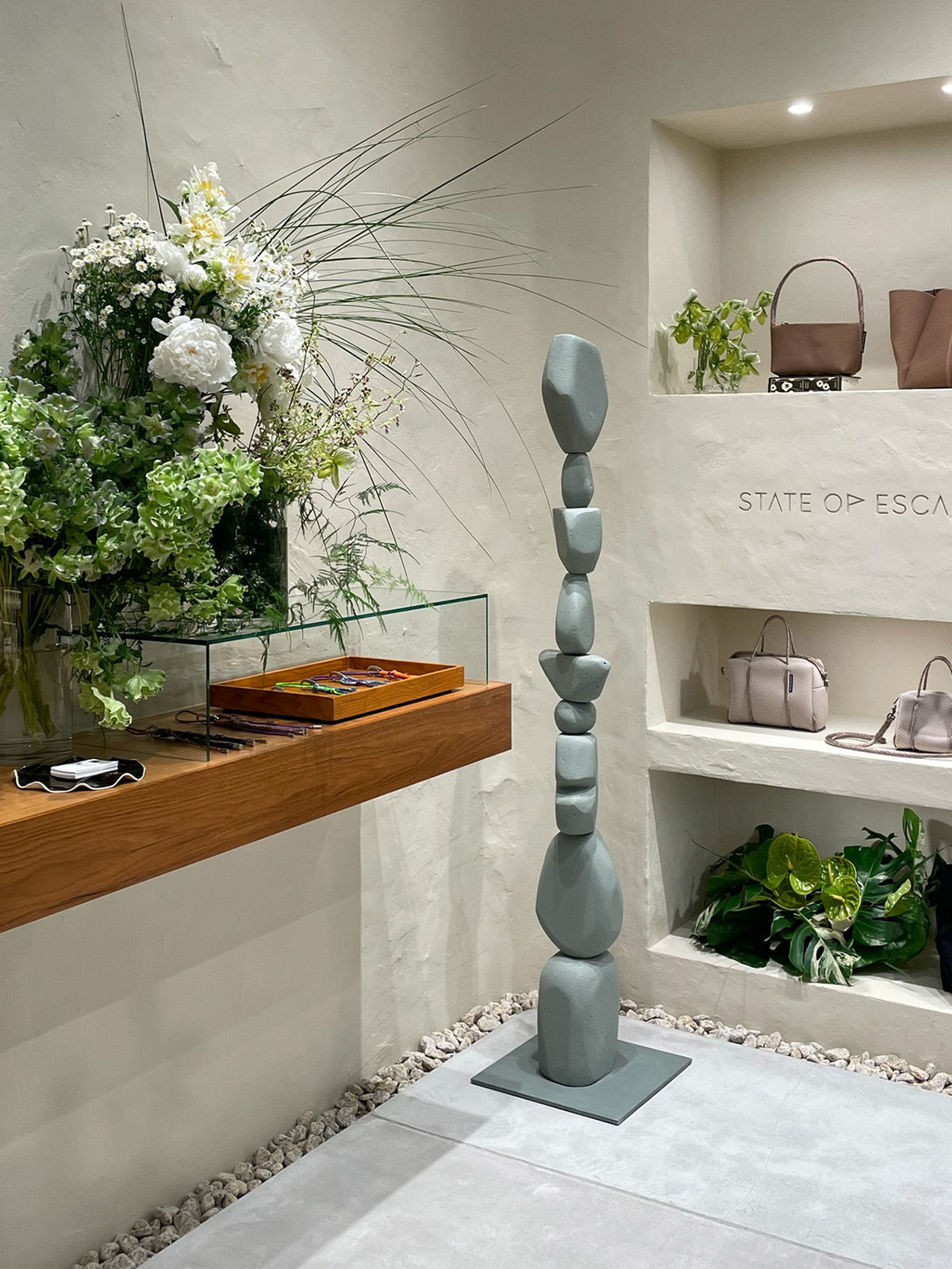 A modern sculpture beside a floral arrangement in a stylish interior.