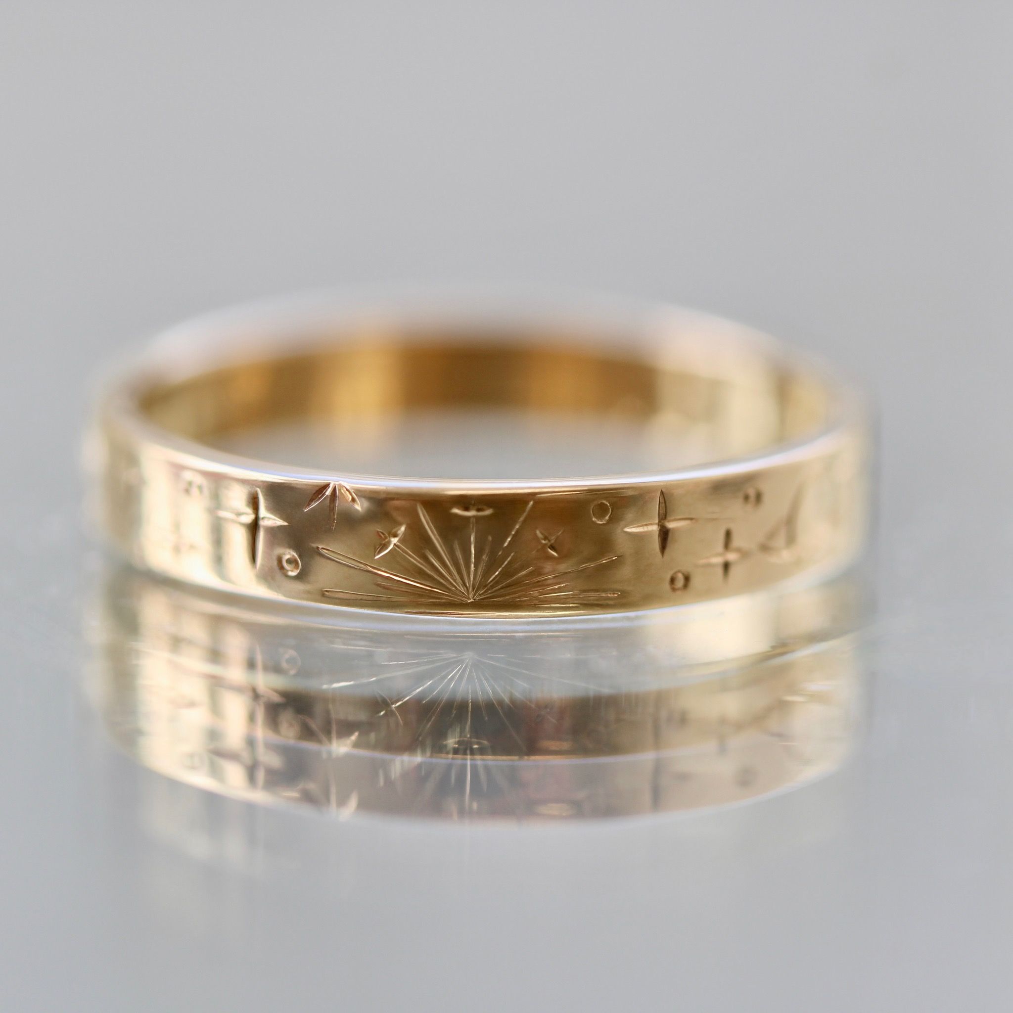 Hand-engraved wedding band with stars and sunbursts