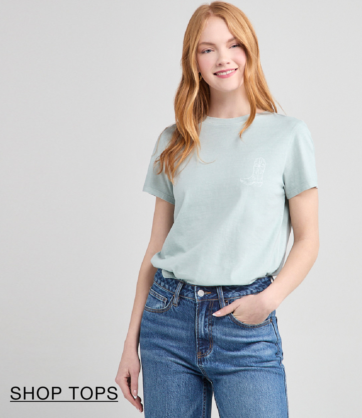 Smiling woman in a light blue shirt and jeans.
