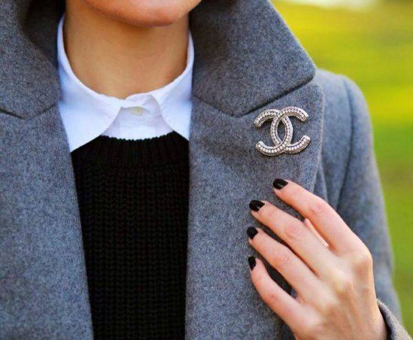 Woman styling her winter coat with an exclusive Channel Brooch