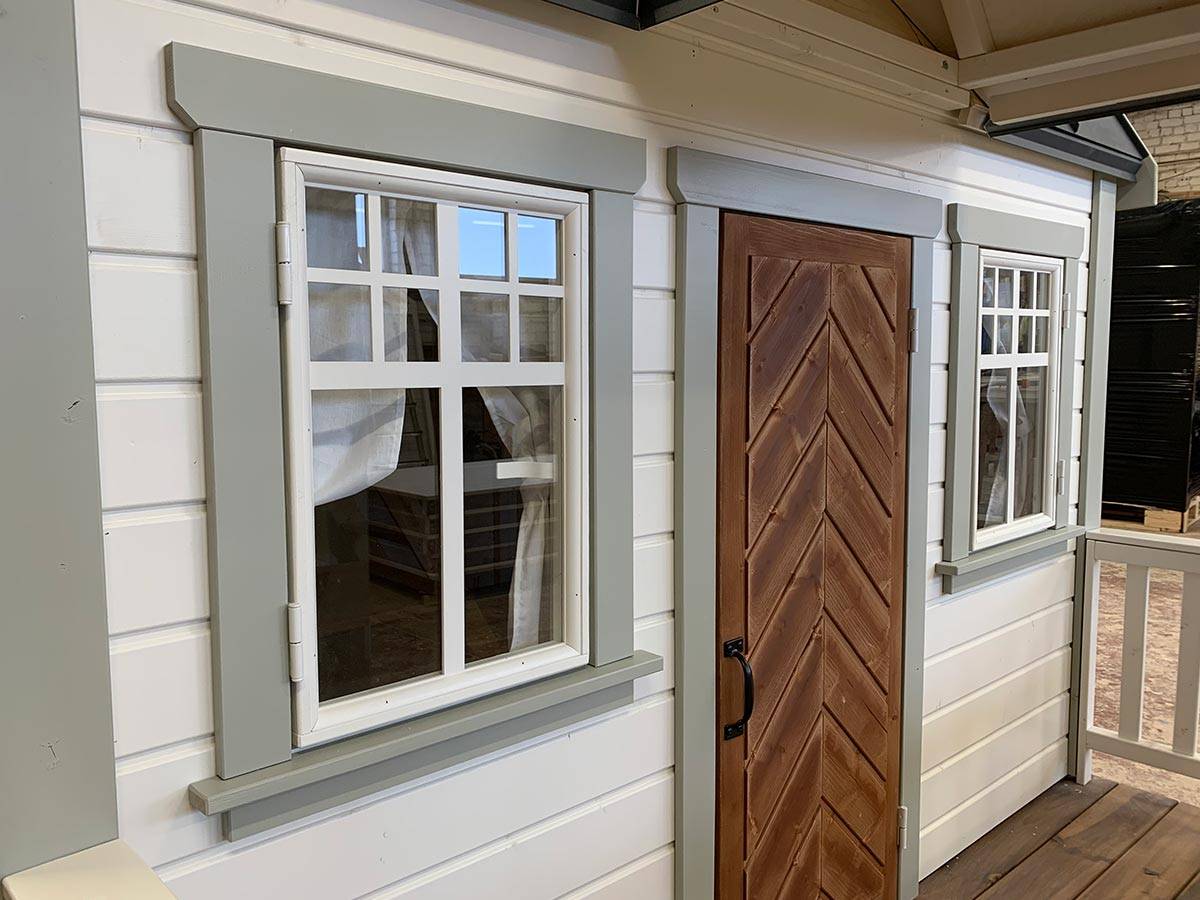 Close up of Farmhouse style Playhouse fisbone door and safety glass windows with gray trims by WholeWoodPlayhouses