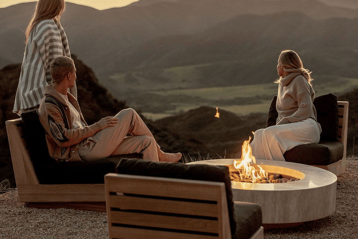 Outdoor fire pit seating area with lounge chairs and mountain views for a cozy evening gathering.
