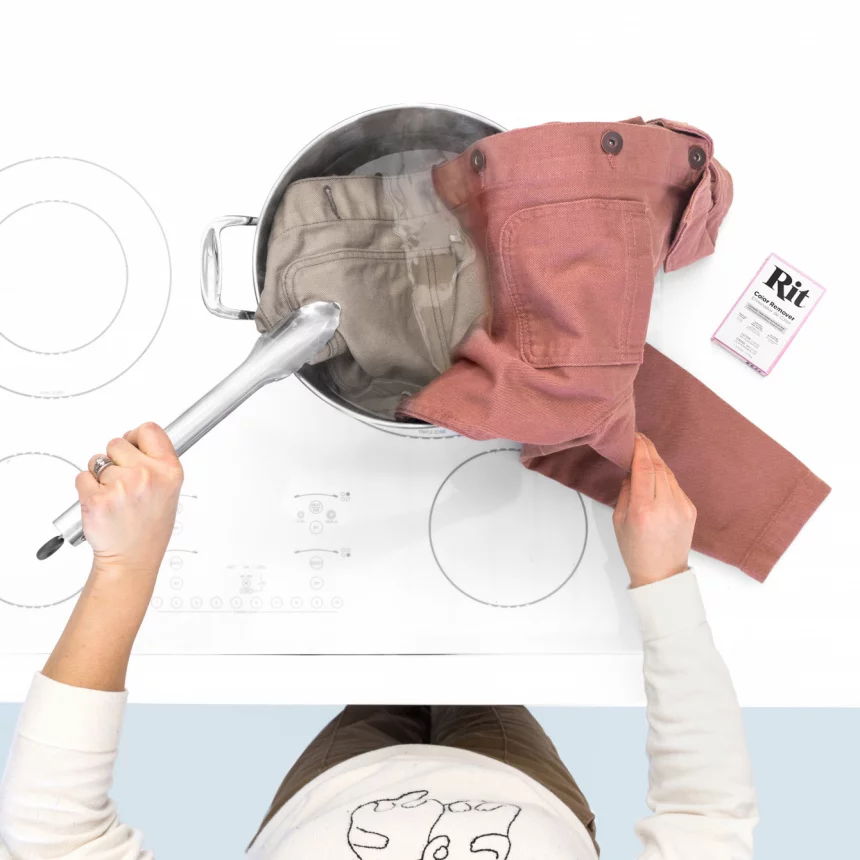 Person dyeing clothes in a pot on a stove.