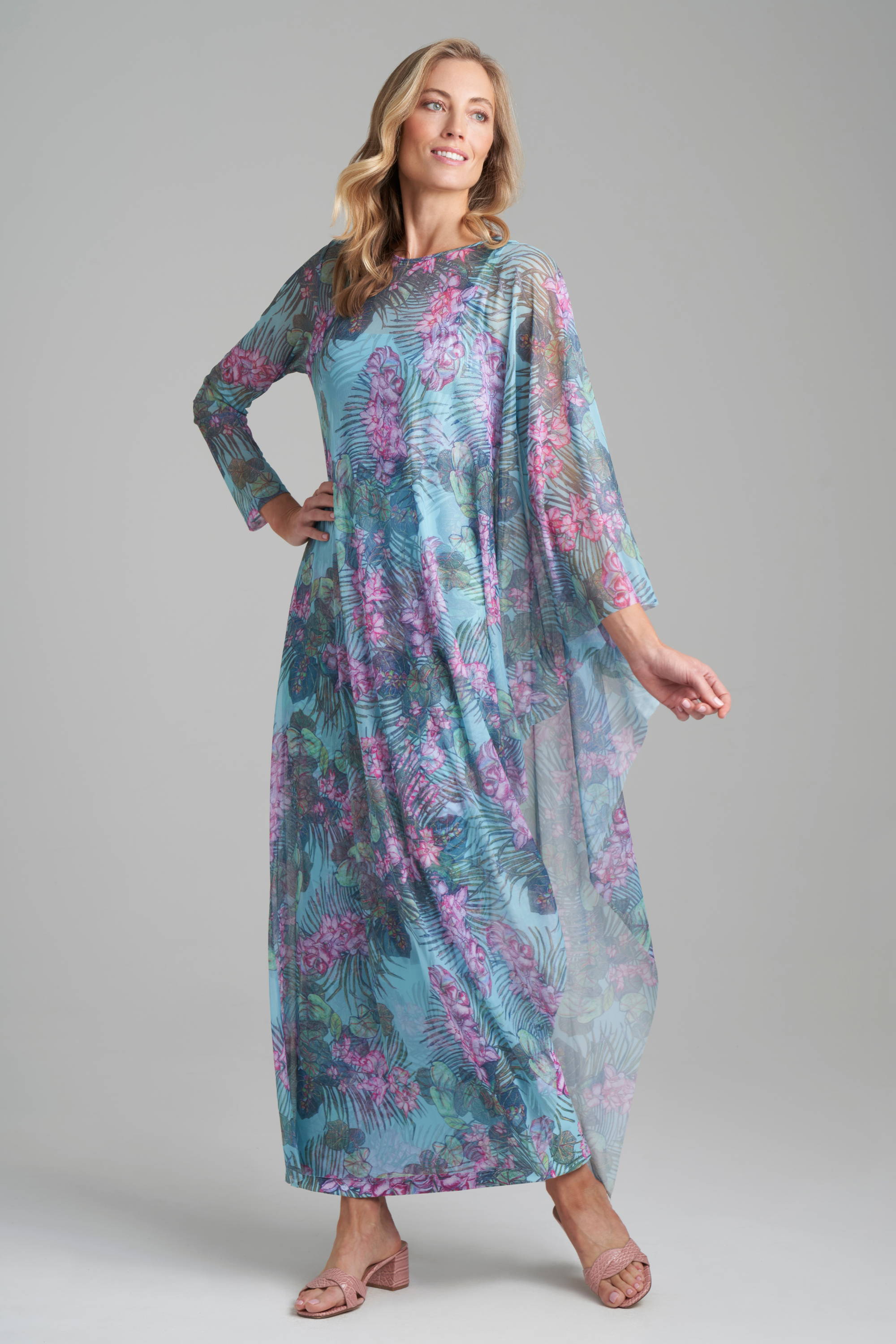 Woman wearing mesh floral printed kaftan over long floral printed stretch knit dress by Ala von Auersperg