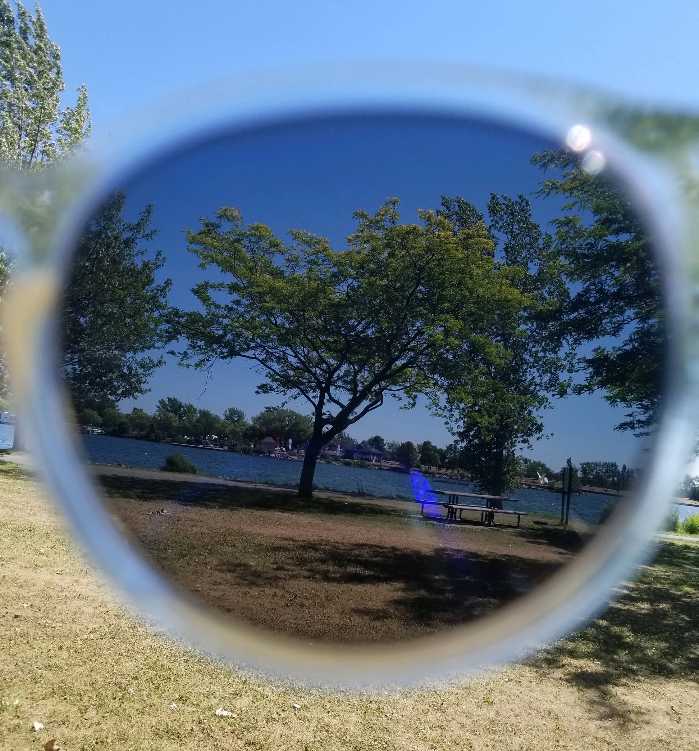Paysage du lac à travers des verres de lunettes de soleil polarisées teintées