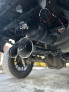 Black air tank and three train horn trumpets installed on the undercarriage of Tanner's Ford F-150