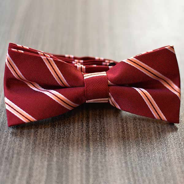 Burgundy pencil striped bow tie on a wool floor