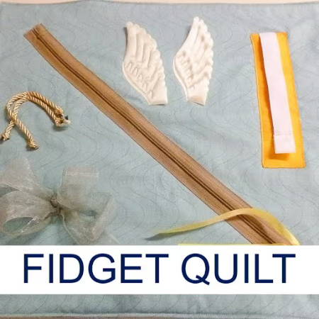 Pale blue fidget quilt with wings, ribbon, zipper,cords 
