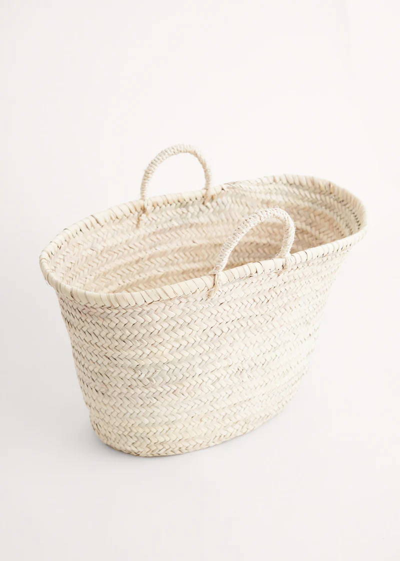 A raffia tote basket with short handles in a natural tone