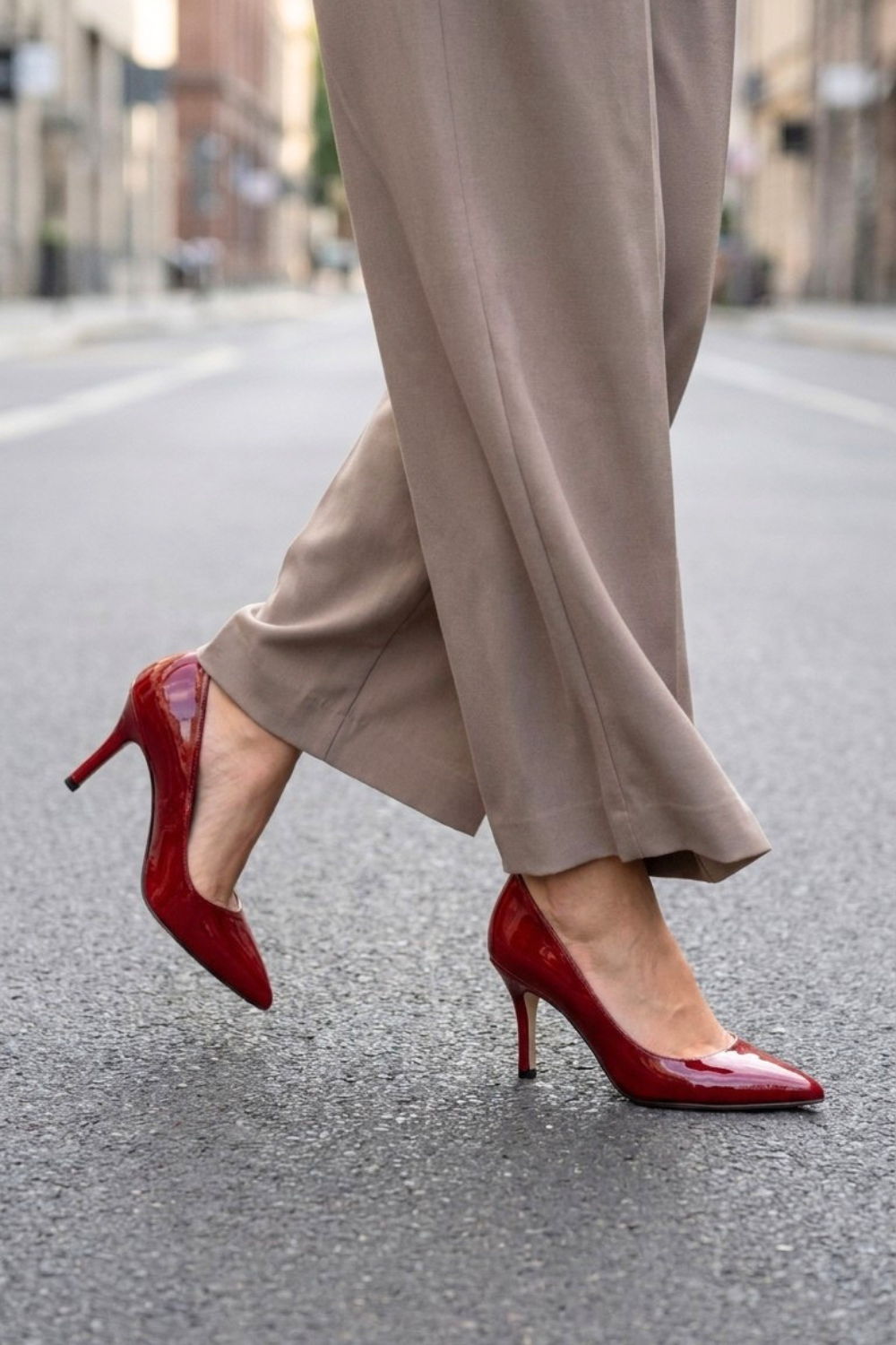 A person walking in red high heels on a city street.