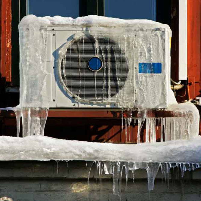 ductless heat pump outside covered in ice during winter