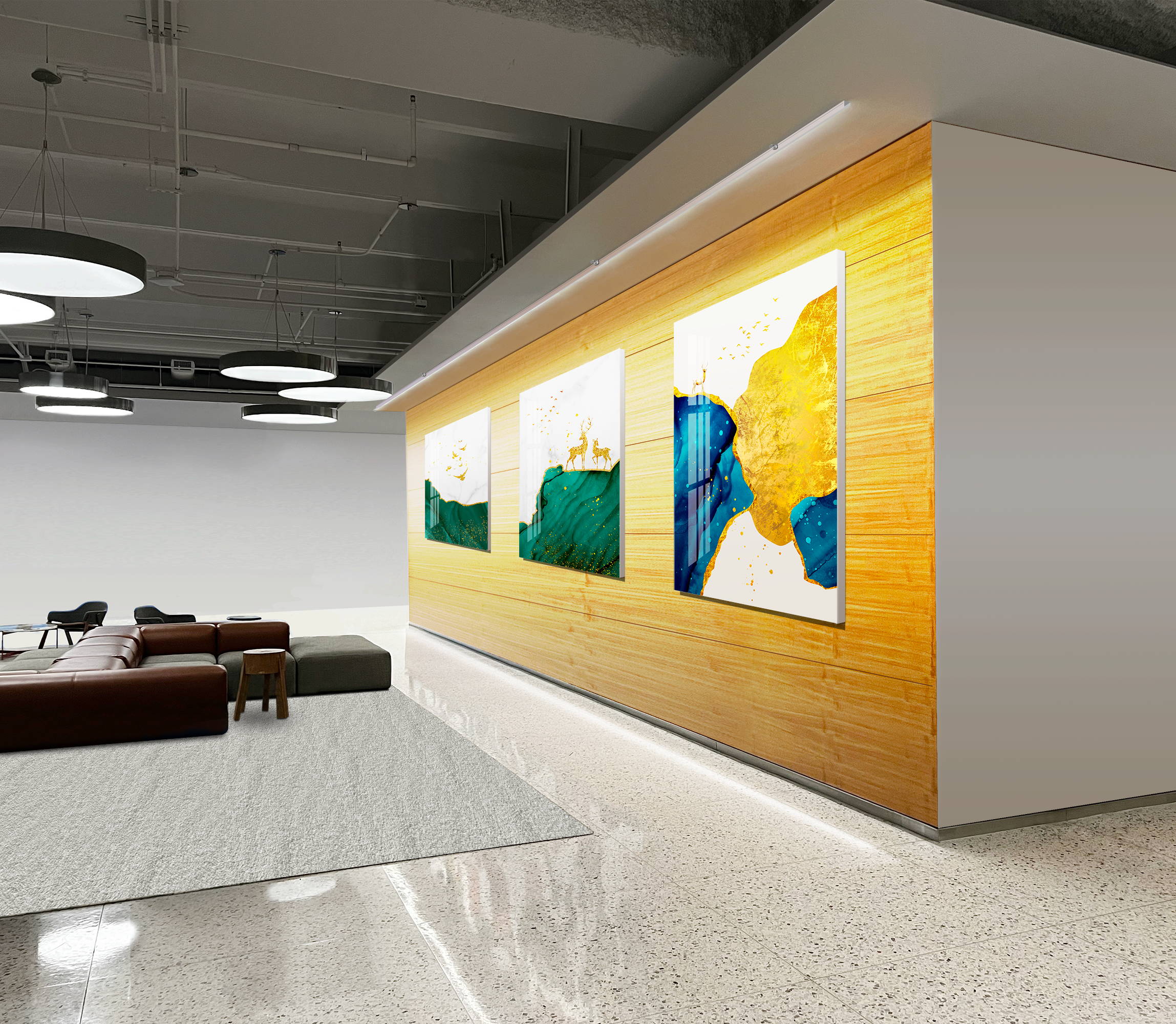 A wall with three art pieces is washed by a linear wall washing light from the top downward in a lounge area.