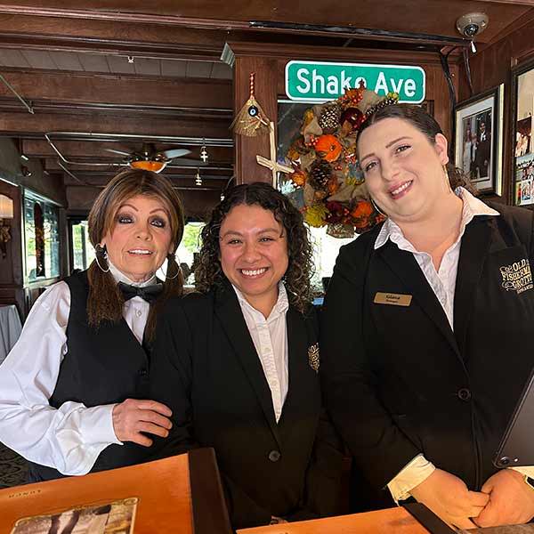 A waitress and hostesses wearing their restaurant uniforms