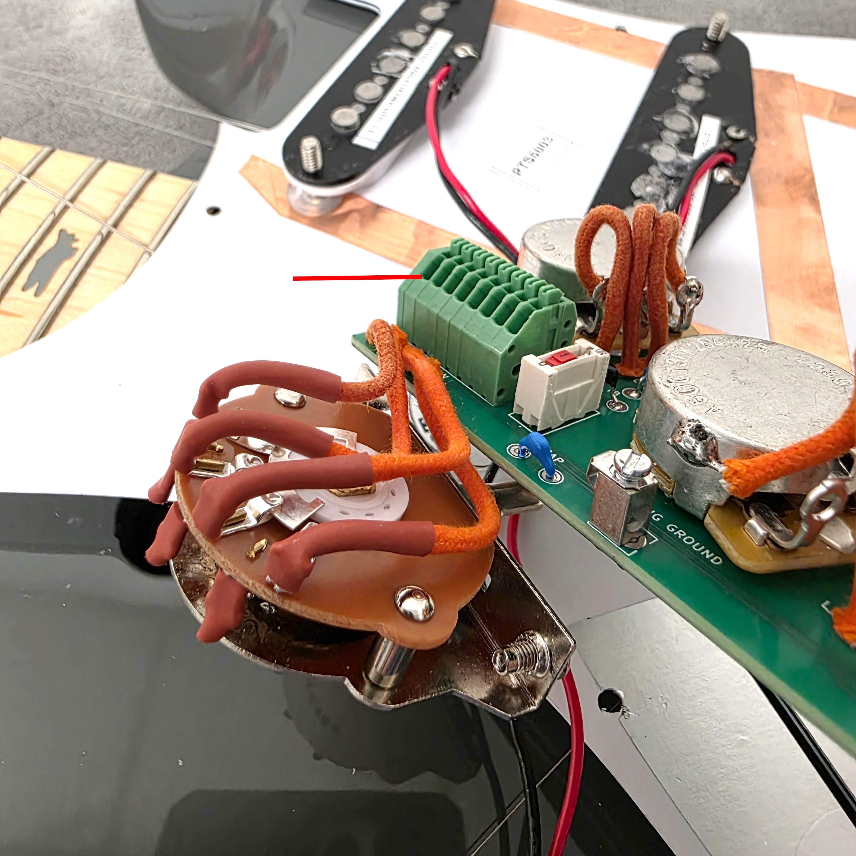 Circuit board with components and wires on a workspace.