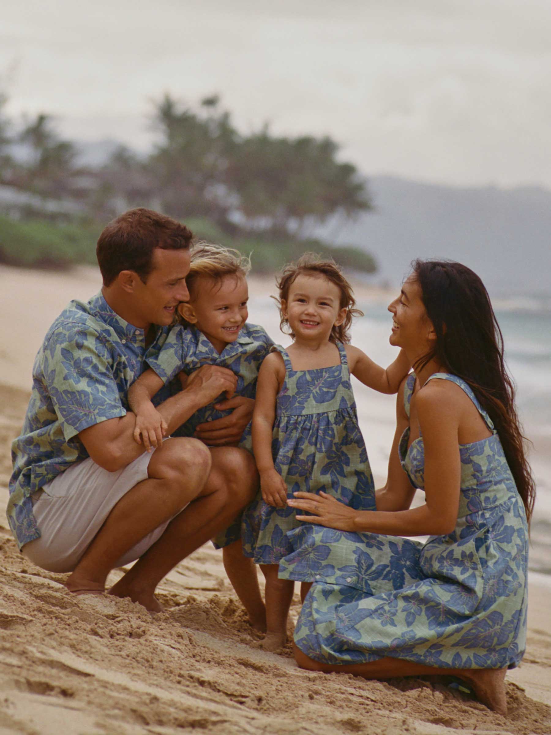 Family in matching outfits enjoying a beach day together.