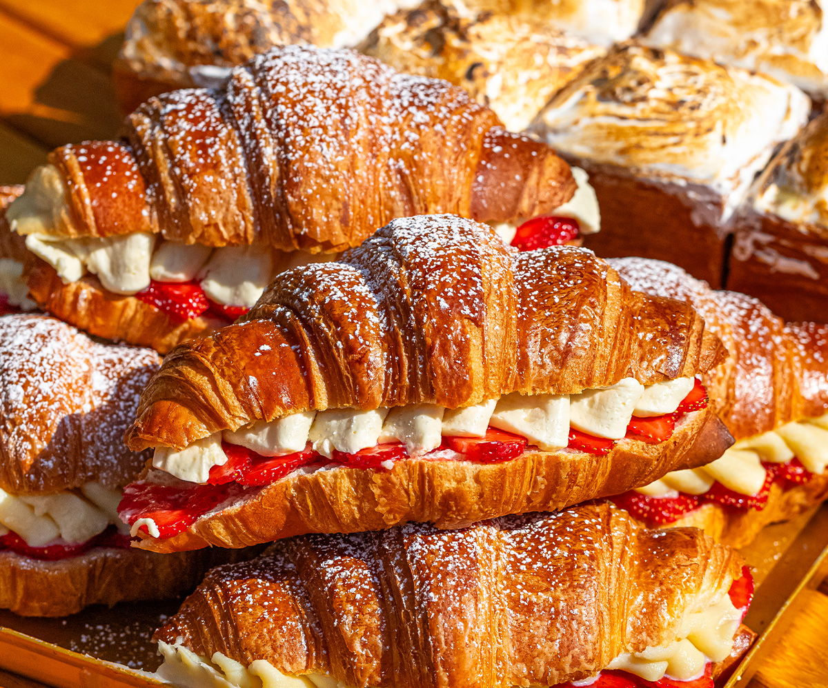 Croissants filled with cream and strawberries, dusted with powdered sugar.