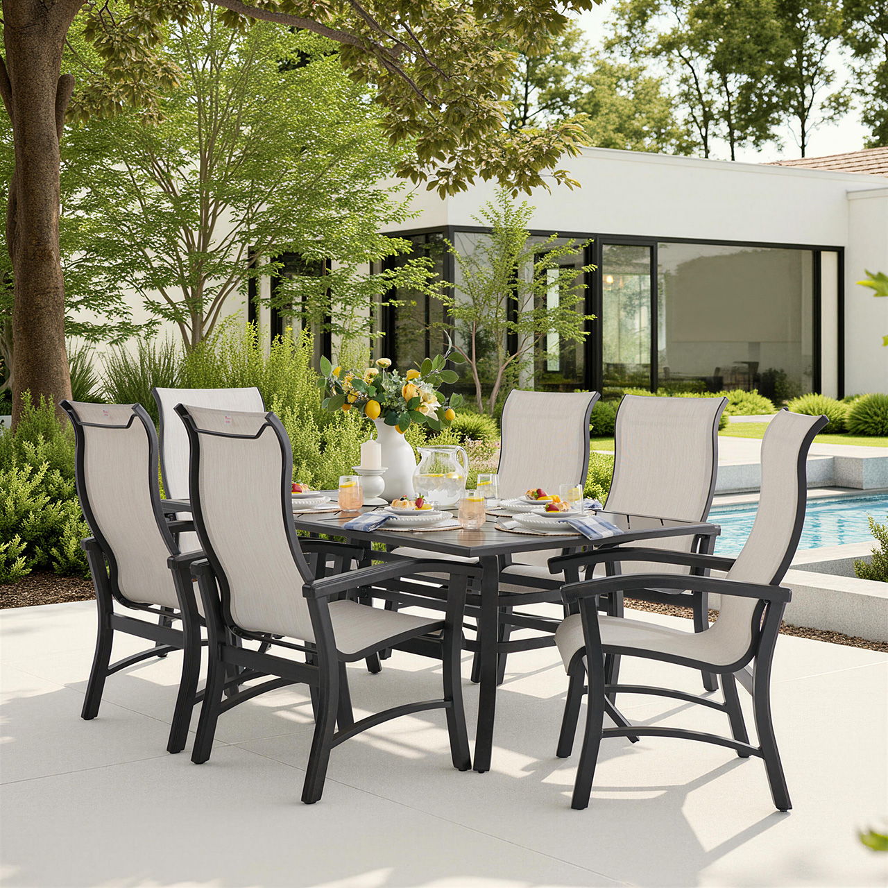 Outdoor dining set with chairs and table near a pool and greenery.