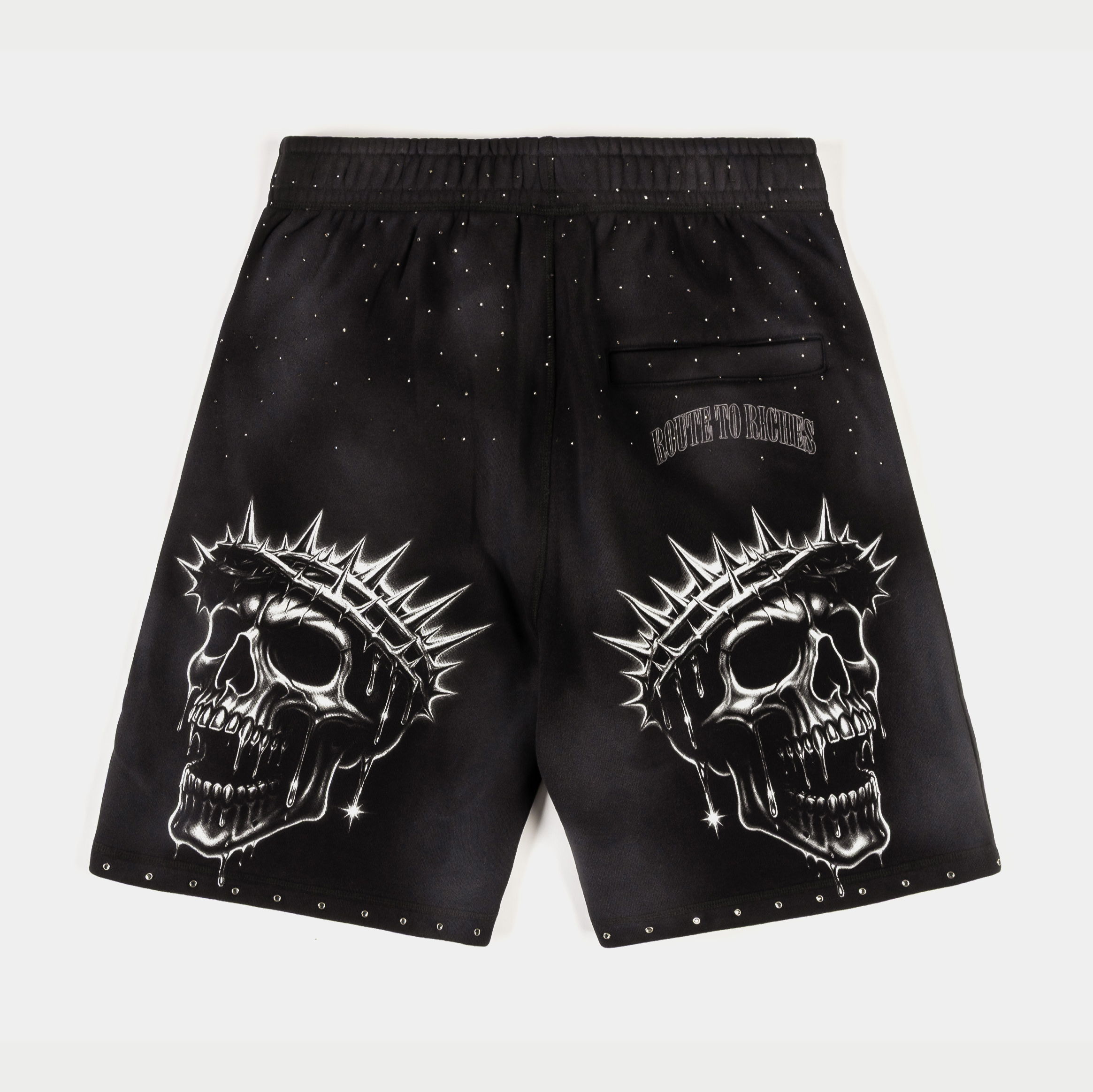 Black shorts featuring skull designs with spiked crowns and decorative studs.