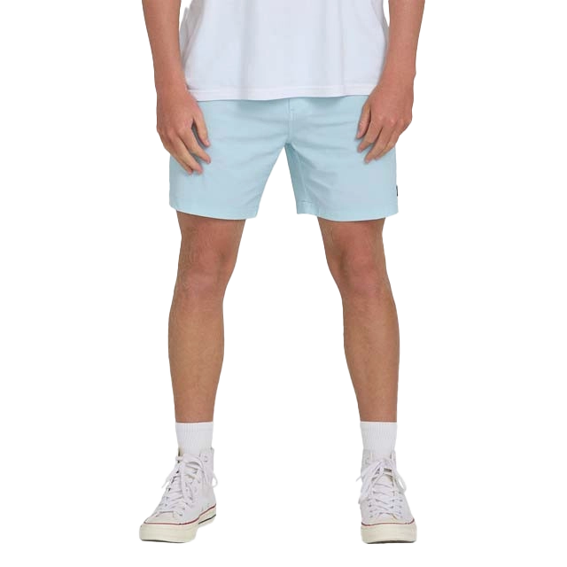 Person wearing light blue shorts and a white t-shirt, standing.