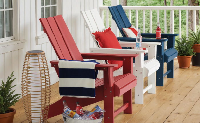 Adirondack chairs in red, white, and blue on a porch.