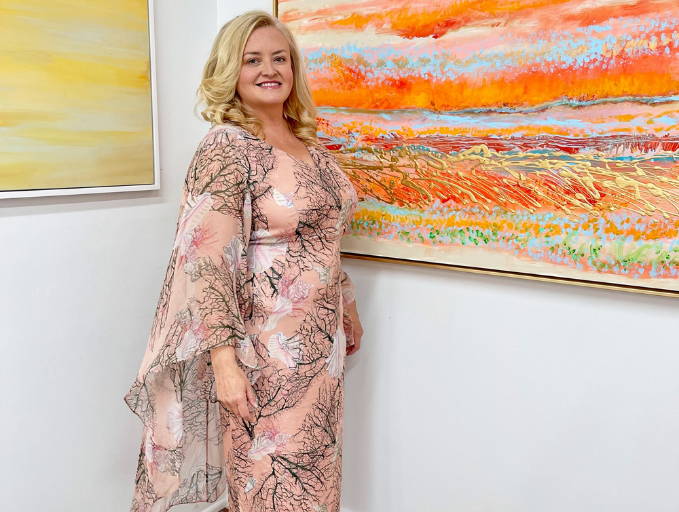 Camilla Webster wearing coral printed peach silk dress with attached caplet by Ala von Auersperg for resort 2022