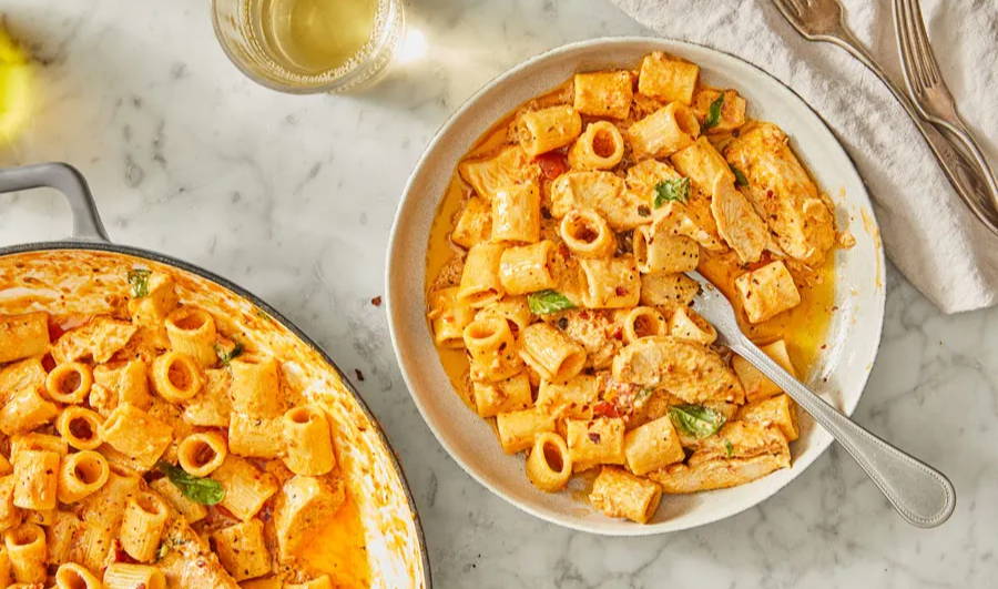 Rigatoni pasta in a creamy tomato and cheese sauce with chicken and served in a bowl