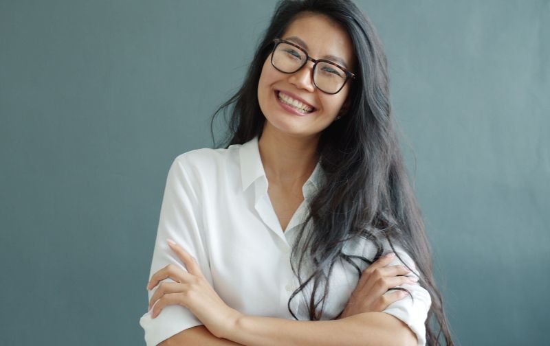 Smiling asian women wearing low bridge glasses design on a blue background