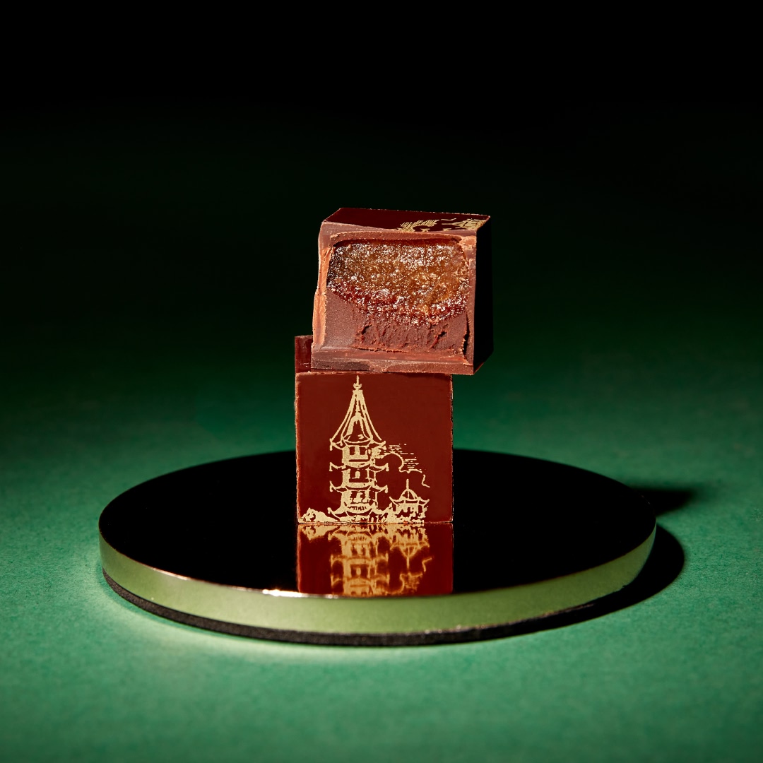 Two decorative boxes on a reflective surface with a dark background.
