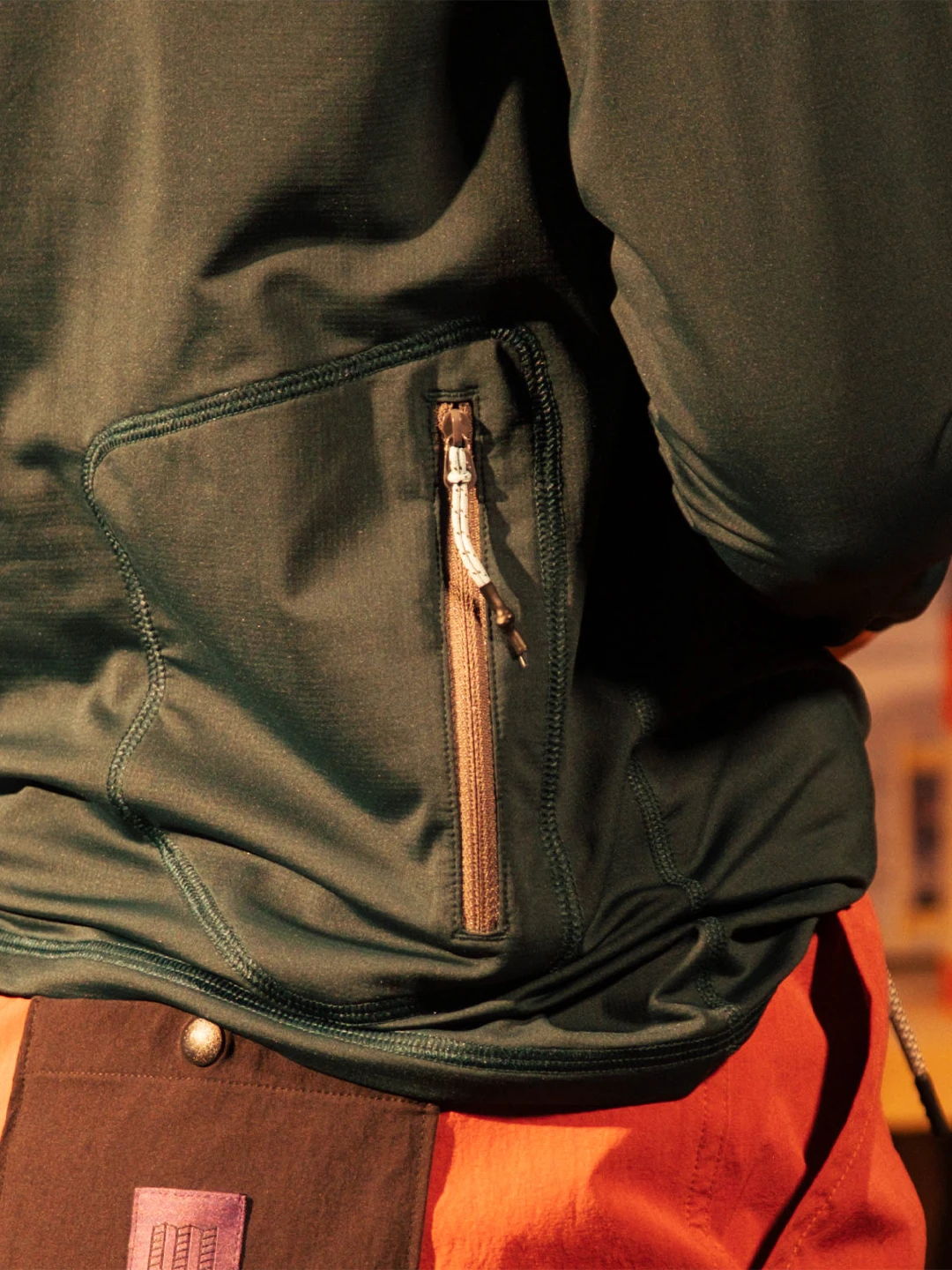 Close-up of a person's jacket pocket with a zipper.