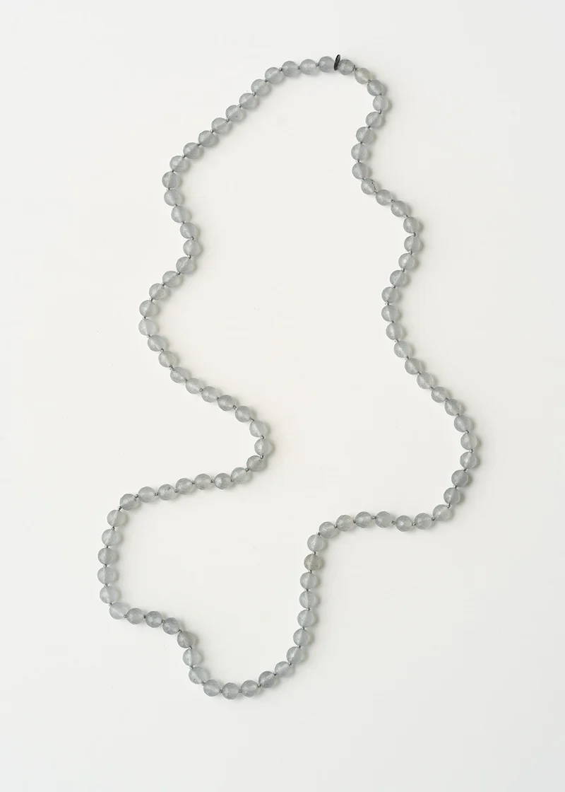 A chunky glass beaded necklace in soft grey tones